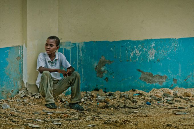 Child sitting with his back to a wall - Dental Mission in the Dominican Republic